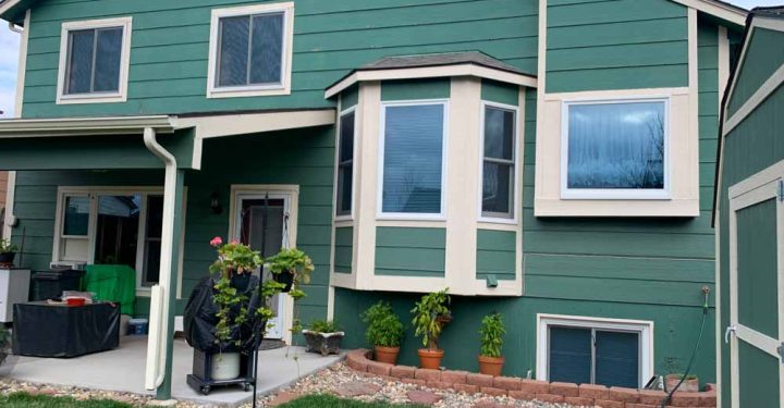 Newly painted exterior of the house with color green, window trims with white and beige