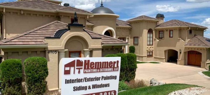 a beautiful home villa with newly painted exterior walls and window trims. in front of the yard is the painting contractor's signage