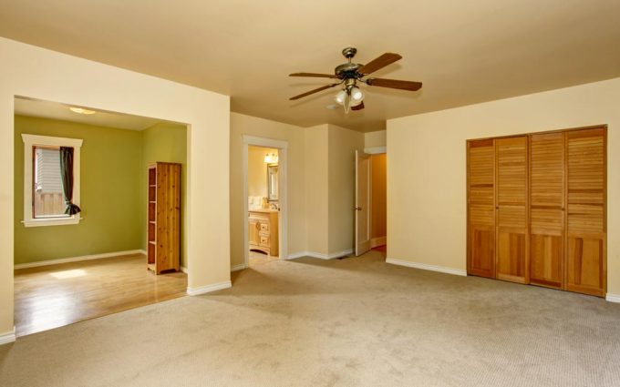 Old craftsman style house with beige interior paint. Carpet floor and built-in closet in empty room.