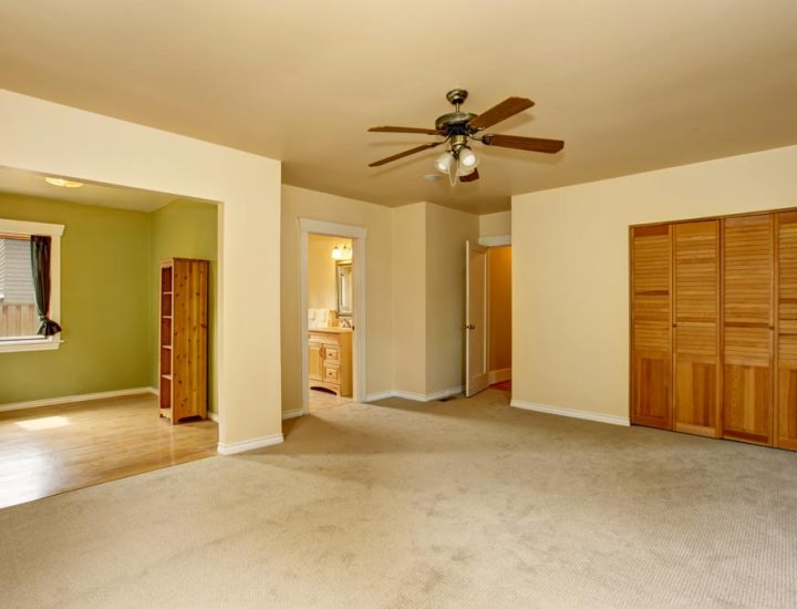 Old craftsman style house with beige interior paint. Carpet floor and built-in closet in empty room.