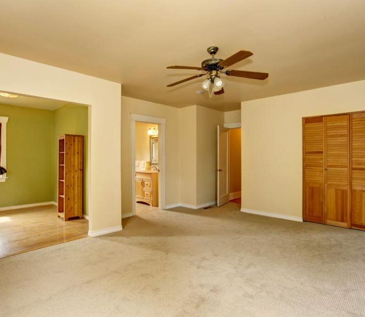 Old craftsman style house with beige interior paint. Carpet floor and built-in closet in empty room.