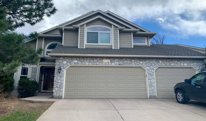 a beautiful house with a newly painted garage doors and a concrete driveway