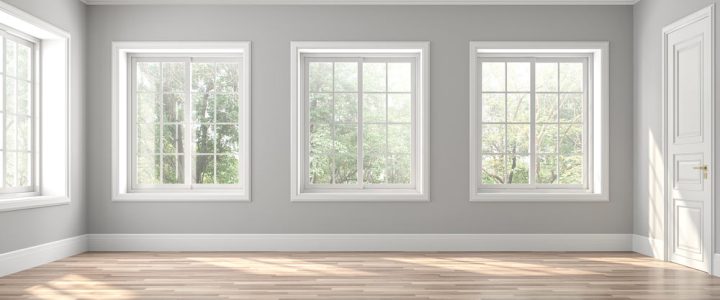 an empty room with windows, trims painted in white, and gray walls and vinyl wood flooring